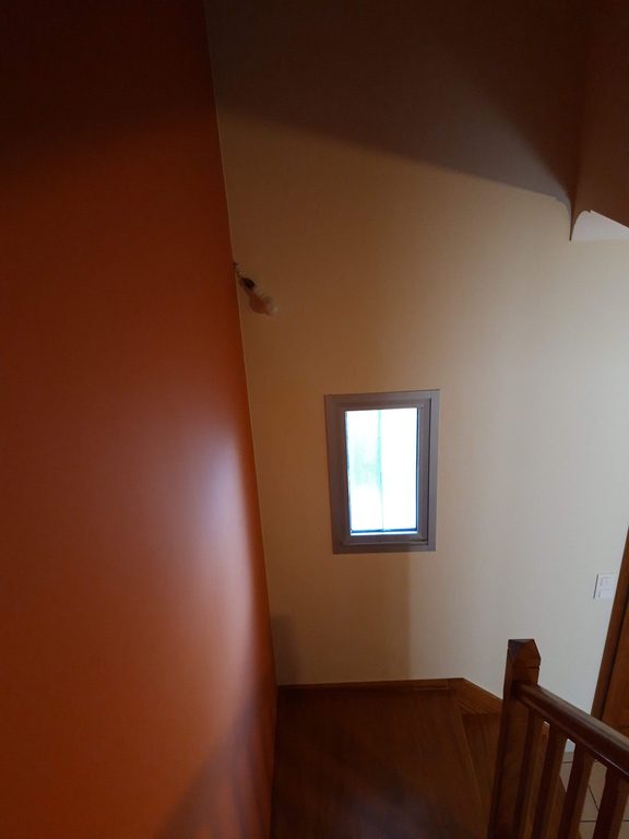 Cage d'escalier — vue vers le haut, bicolore blanc et terracotta