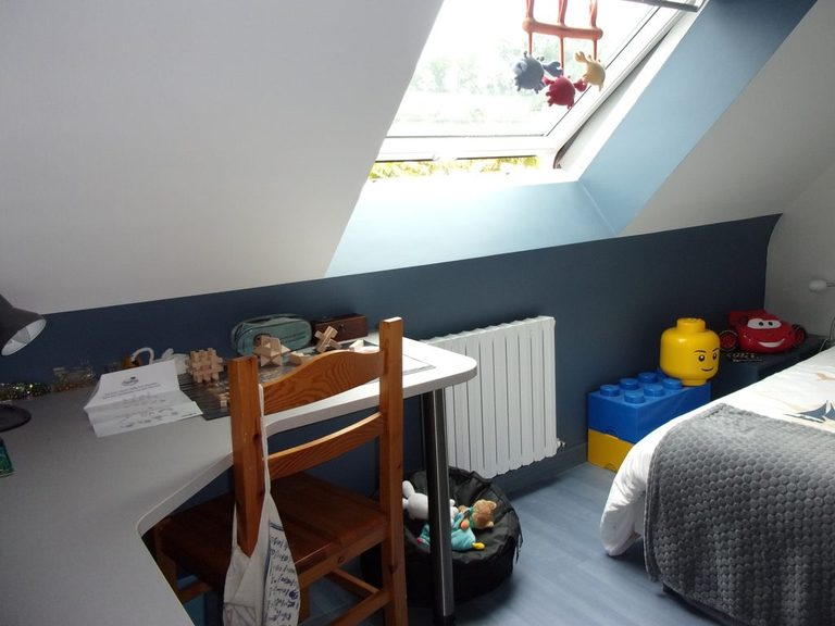 Coin bureau sous fenêtre de toit, mur bleu ardoise et radiateur blanc
