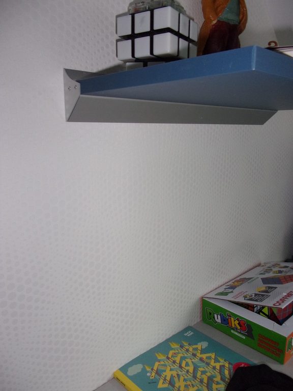 Étagère bleue posée sur le mur blanc texturé