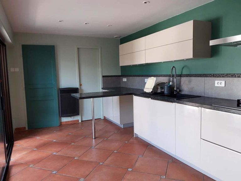 Vue de la cuisine depuis l’entrée — camaïeu de verts et sol en tomettes