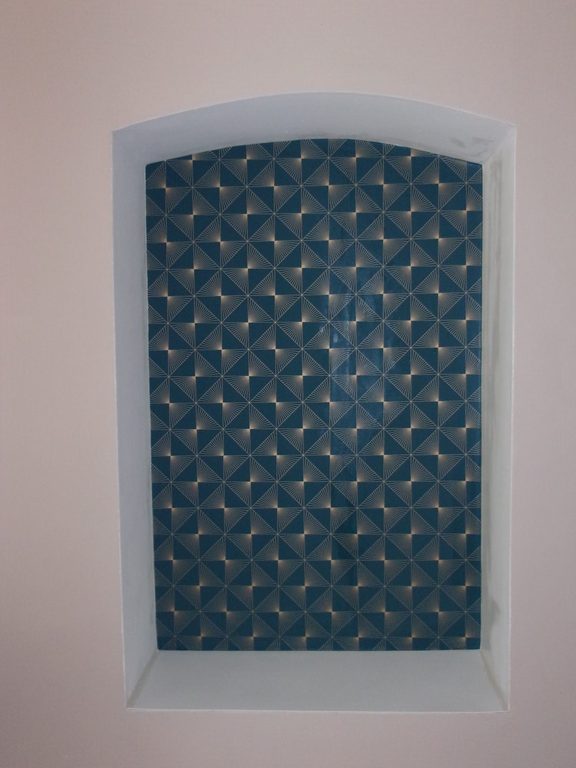 Papier peint dans une niche — motif géométrique bleu pétrole