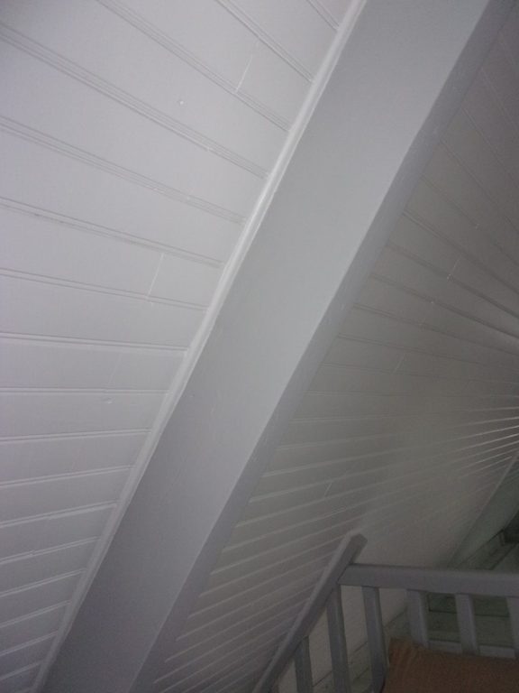 Détail de la pente de toit et du garde-corps peints en blanc