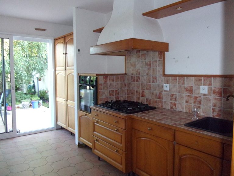 Avant relooking : cuisine en pin donnant sur la porte-fenêtre