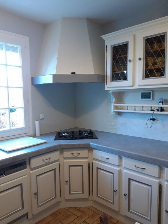 Cuisine des années 70 entièrement rénovée à Carquefou — façades crème et plan de travail effet béton