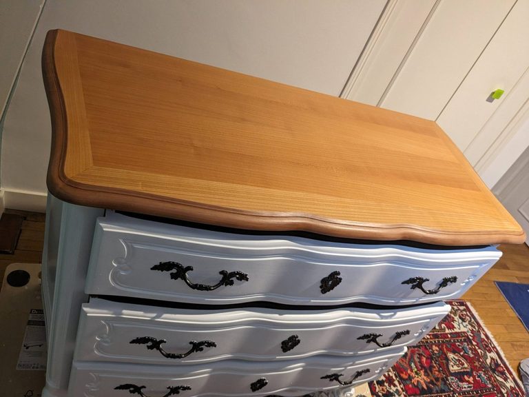 La commode de trois quarts, plateau en merisier verni et corps blanc