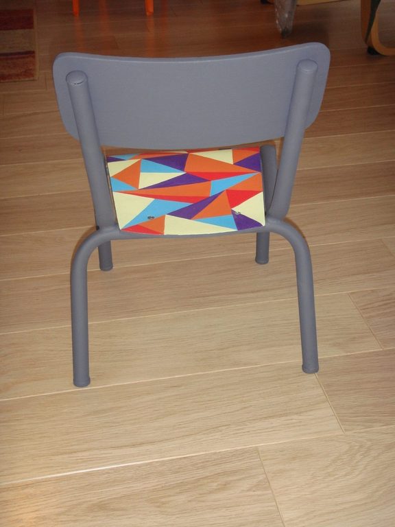 La chaise vue de dos : dossier gris uni et assise colorée
