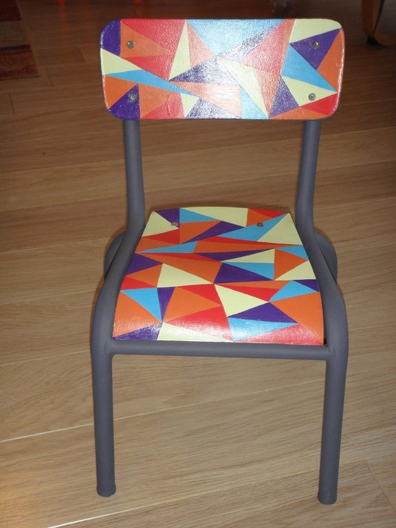 Chaise d'enfant de trois quarts, structure grise et triangles orange et bleus