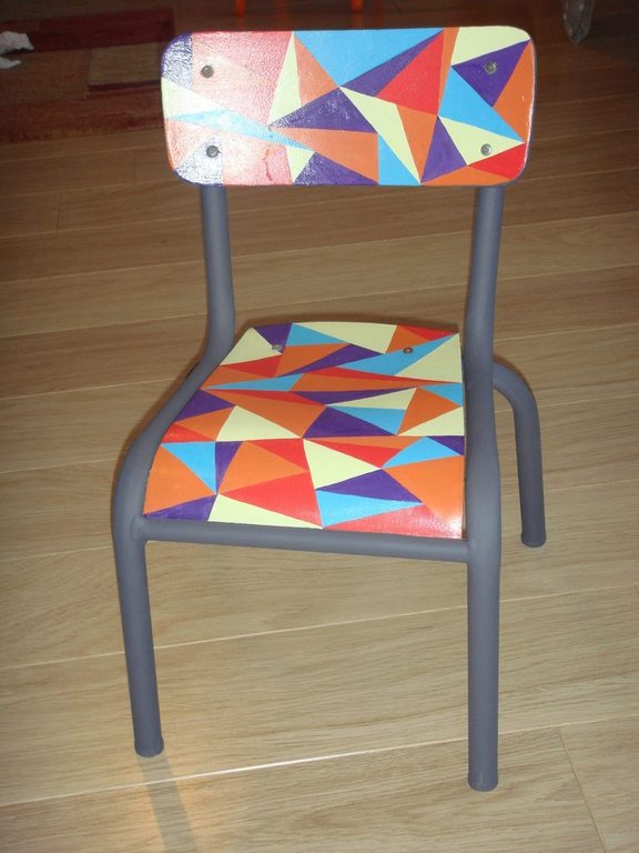 Vue rapprochée de la chaise, motif géométrique sur l'assise et le dossier