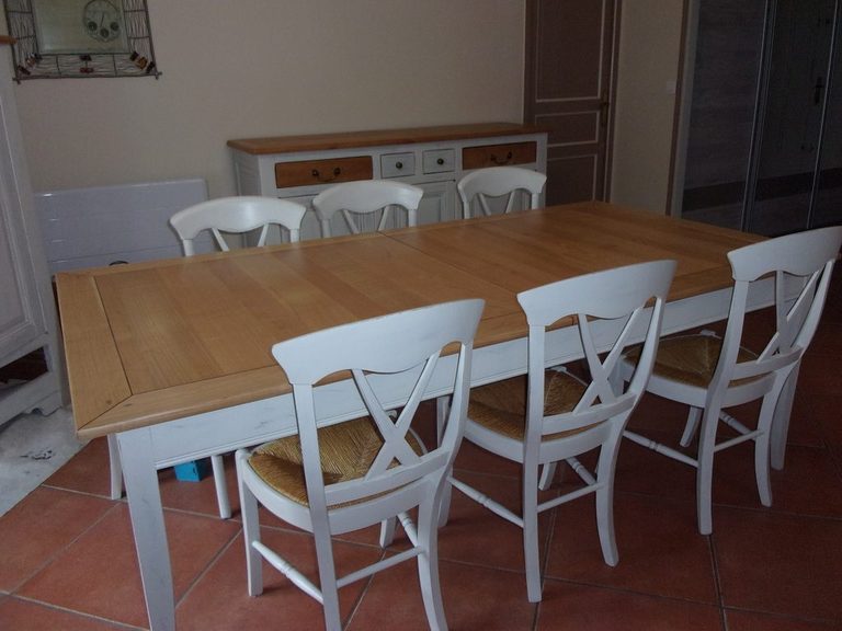 Table dressée entourée des chaises repeintes en blanc