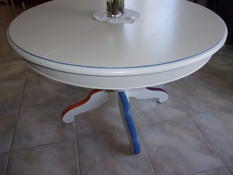 Table ronde repeinte en blanc, pied central aux couleurs vives