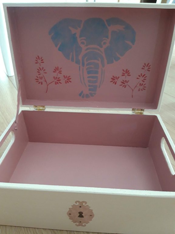 Intérieur du coffre peint en rose, éléphant au pochoir sur le fond
